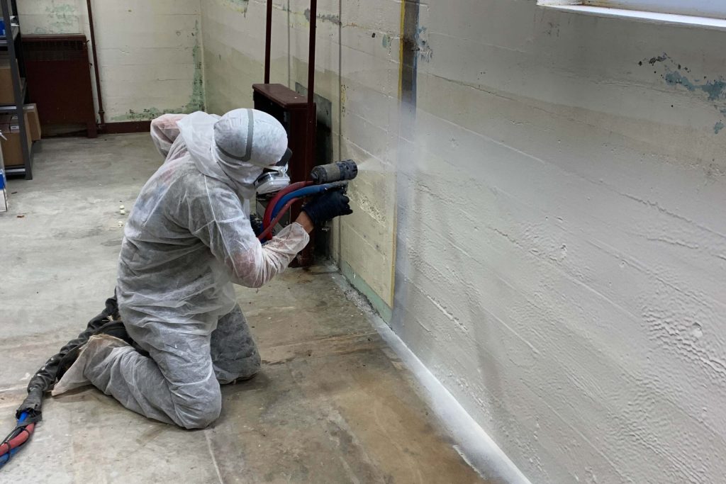 Applicator spraying polyurea coating